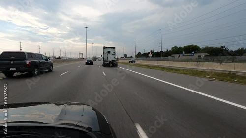 POV car: Canadian highway with vehicles and overcast sky photo