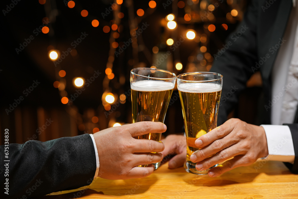 food and drink male friends are happy drinking beer and clinking glasses at a bar or pub.