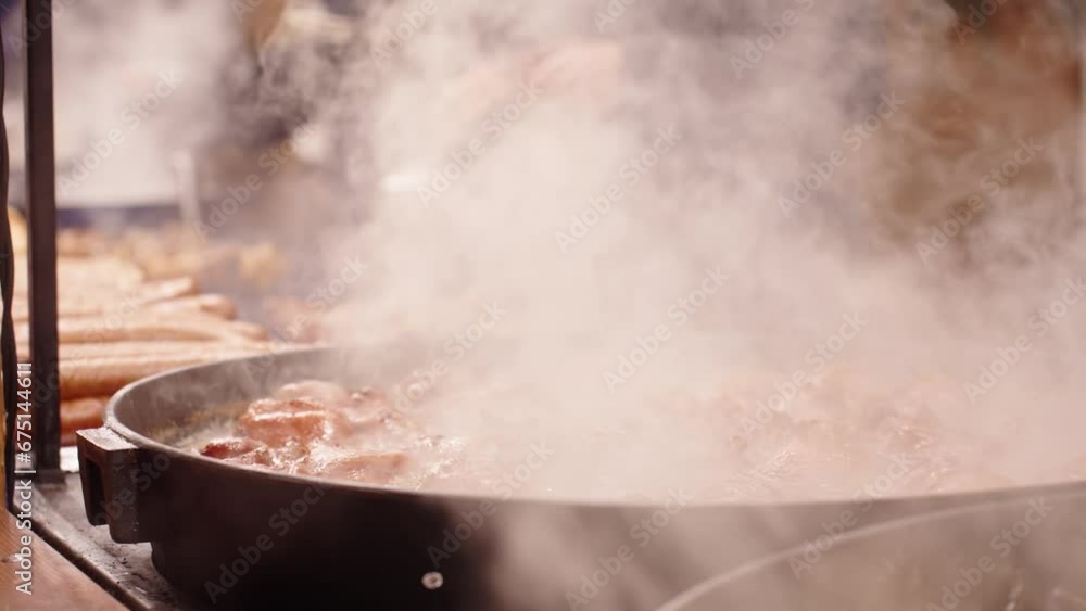 Process of cooking street food outdoors. Frying pan with fried dishes. Christmas Fair at Wroclaw main square Process of cooking street food outdoors. Frying pan with fried dishes. Christmas Fair at Wroclaw main square