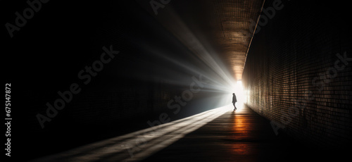 Light Piercing Darkness Description, A person standing in a tunnel with sunlight streaming through the exit photo