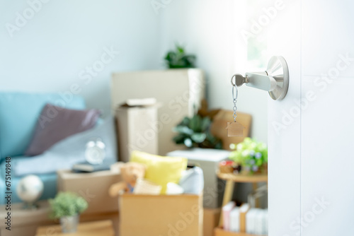 Moving house, relocation. The key was inserted into the door of the new house, inside the room was a cardboard box containing personal belongings and furniture. move in the apartment or condominium.