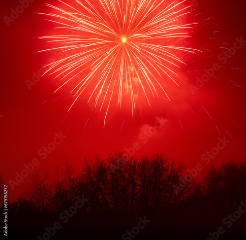 Red firework over trees long exposure