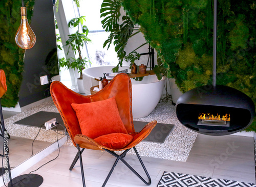 Modern tan leather armchair in an eco-friendly interior with a fireplace. Cozy home. Design concept.