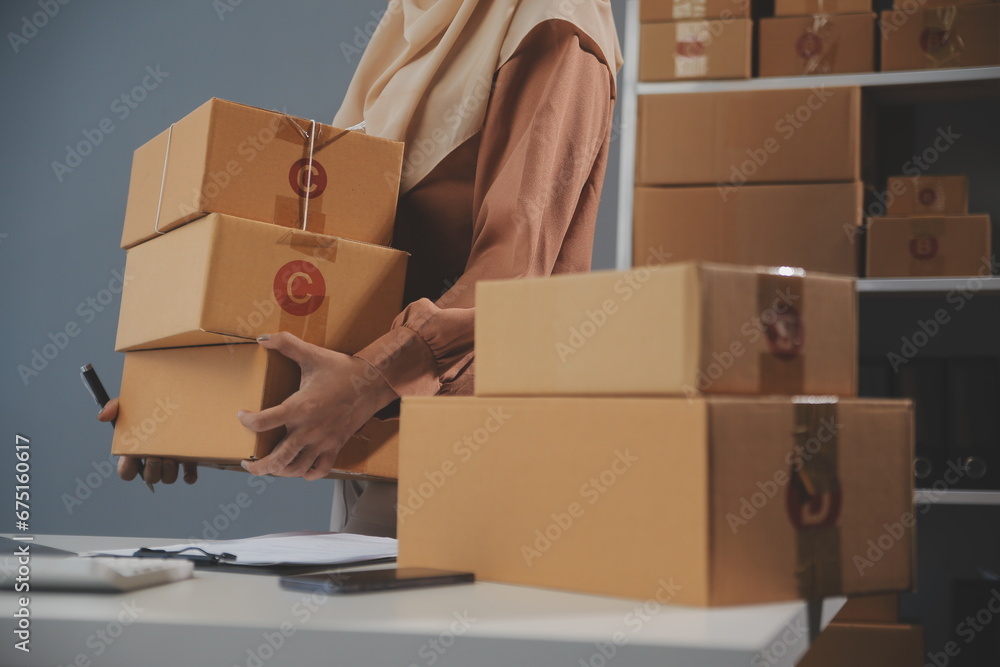 Fototapeta premium Starting small businesses SME owners female entrepreneurs Write the address on receipt box and check online orders to prepare to pack the boxes, sell to customers, sme business ideas online.