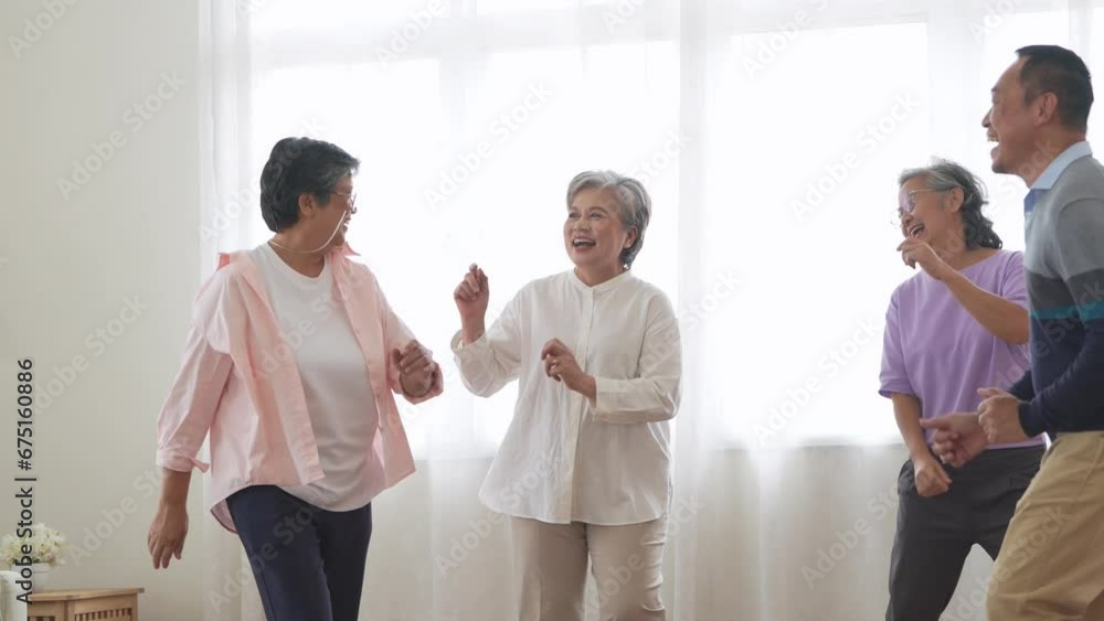 Asian Older male and females people dance with their partners on a dancing floor in living space. Happy older couple performing get exercise. Joyful carefree retired senior friends enjoying relaxation Asian Older male and females people dance with their partners on a dancing floor in living space. Happy older couple performing get exercise. Joyful carefree retired senior friends enjoying relaxation