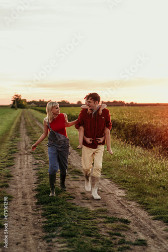 A joyful daughter runs to her beaming parents amidst the stunning countryside sunset, a perfect end to their day