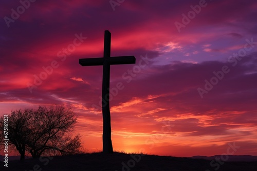 Silhouette of a cross on against a colorful sunset sky