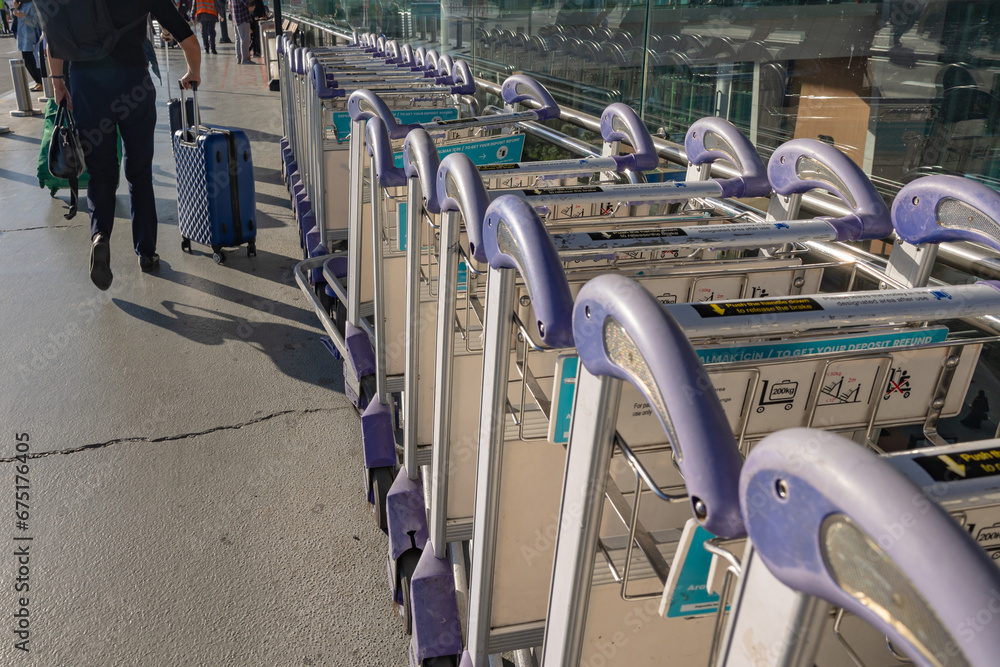 Airport trolleys or luggage trolleys row with passengers.