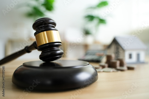 Judge Auctions and the Real Estate Legal System House model and hammer with icons on wooden table Laws governing foreclosures and bankruptcies, debts, or encumbrances. photo