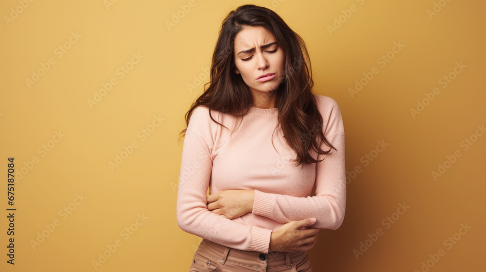 Obraz premium sad young woman holding her stomach, illness, cramps, health, color background, girl suffering, painful periods, stomach-ache, abdominal, griping, bellyache, tummy-ache, gripes, portrait, ill, pastel