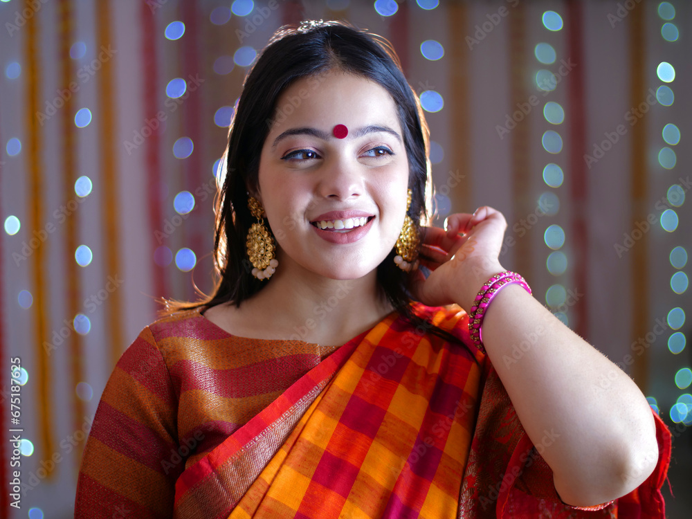 Beautiful Indian Bengali woman dressed in traditional outfit posing for