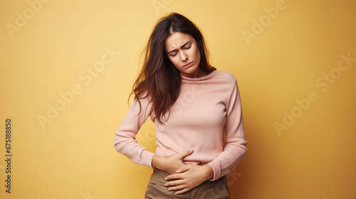 sad young woman holding her stomach, illness, cramps, health, color background, girl suffering, painful periods, stomach-ache, abdominal, griping, bellyache, tummy-ache, gripes, portrait, ill, pastel