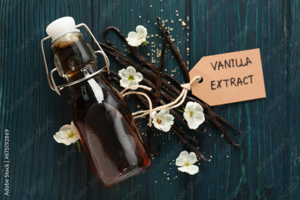 Vanilla extract in a bottle on a wooden table - obrazy, fototapety, plakaty 