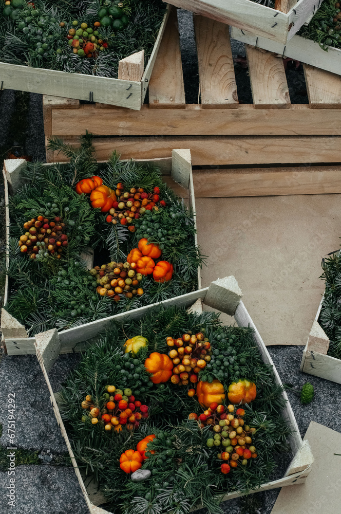 Wooden boxes with autumn composition of wreath and decoration at the market.