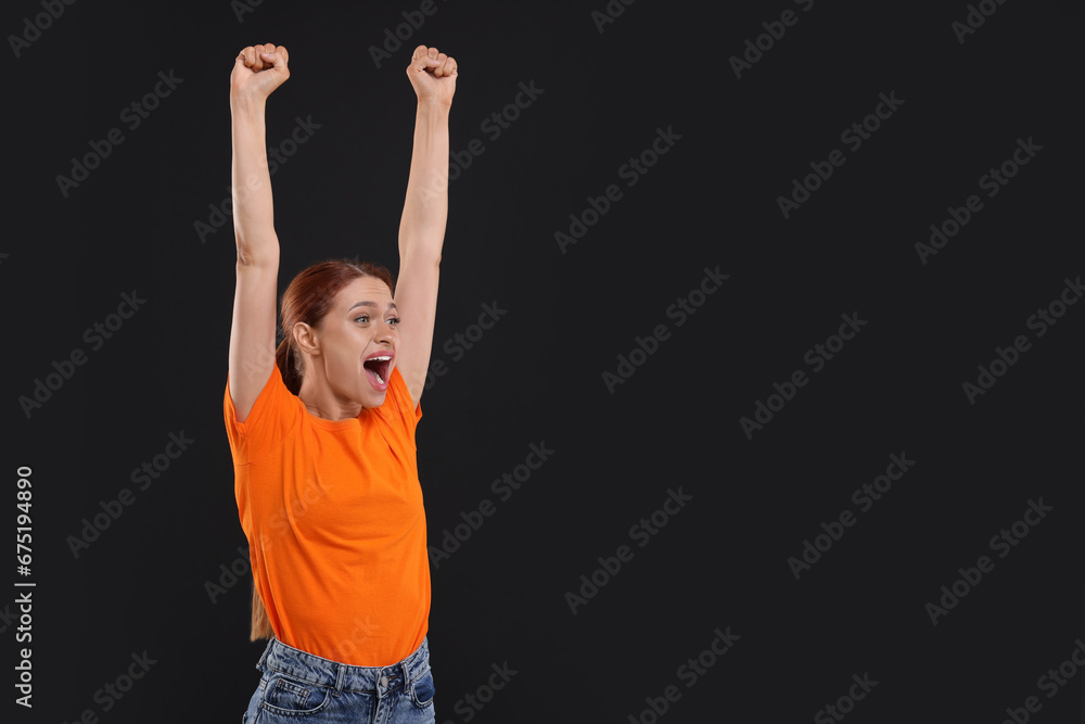 Emotional fan celebrating on black background, space for text Emotional fan celebrating on black background, space for text