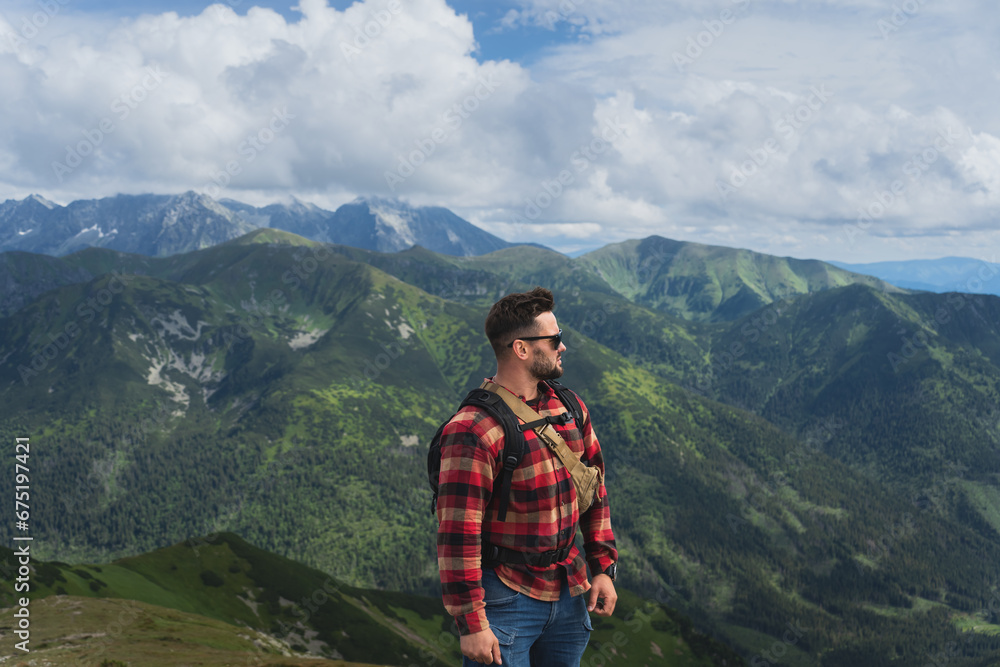 A man in a shirt is a traveler on the top of the Polish Tatra Mountains.