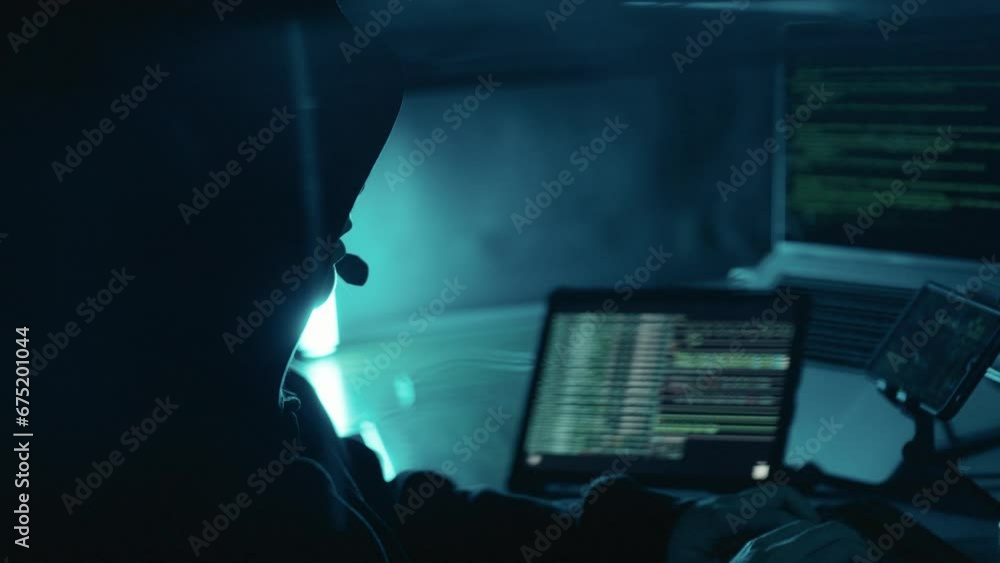 Hacker Switching Off A Computer A hacker working on laptop at night. Hacker using computer breaks into ...
