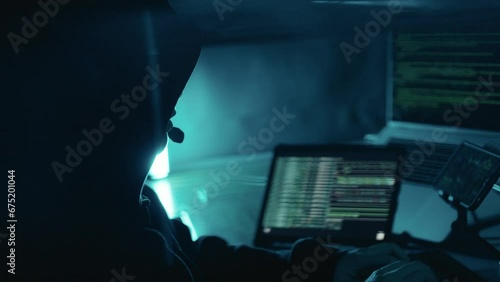 A hacker working on laptop at night. Hacker using computer breaks into government data servers and infects their systems with a virus. Hacker, Cyber security, Cyber crime concept photo