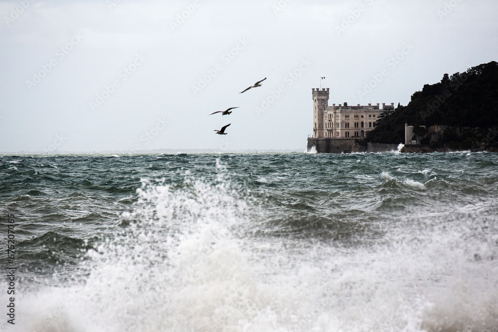 stormy sea with Miramare castle in the back