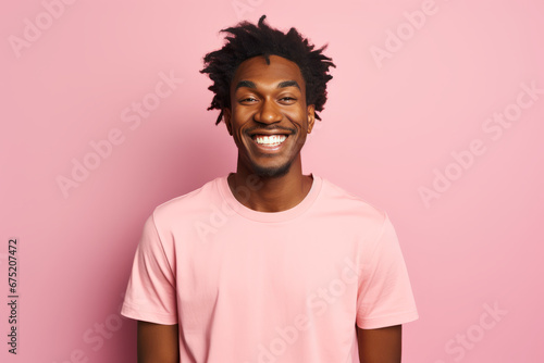 Close up portrait of young smiling handsome guy in pink t-shirt isolated on pink background © GustavsMD