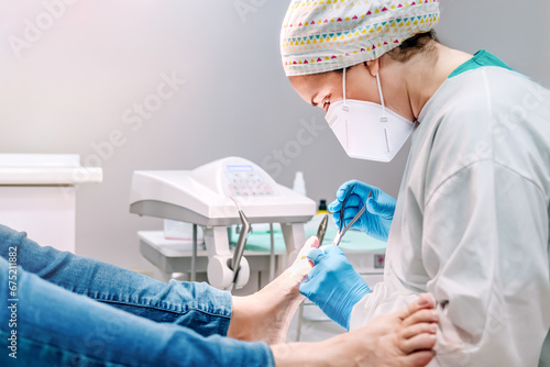 Foto Female podiatrist doing chiropody in her podiatry clinic