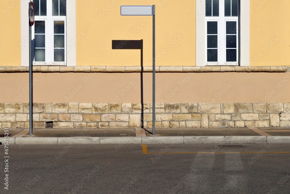 custom made wallpaper toronto digitalPole with blank directional sign on sidewalk. Facade made of plaster and stones with two large windows. Urban street in front. Background for copy space.