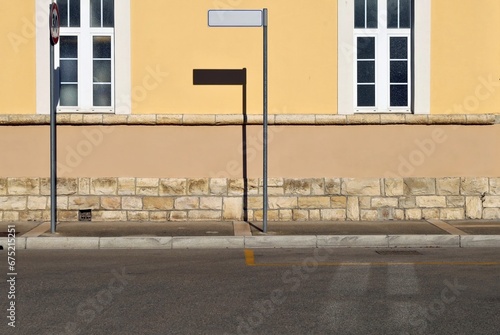 Wallpaper Mural Pole with blank directional sign on sidewalk. Facade made of plaster and stones with two large windows. Urban street in front. Background for copy space. Torontodigital.ca