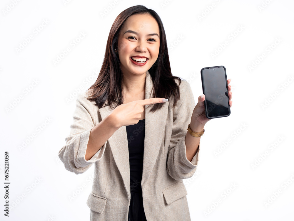 A portrait of an Indonesian Asian woman wearing a cream-colored blazer, showcasing a blank smartphone screen. Isolated against a white background. A portrait of an Indonesian Asian woman wearing a cream-colored blazer, showcasing a blank smartphone screen. Isolated against a white background.