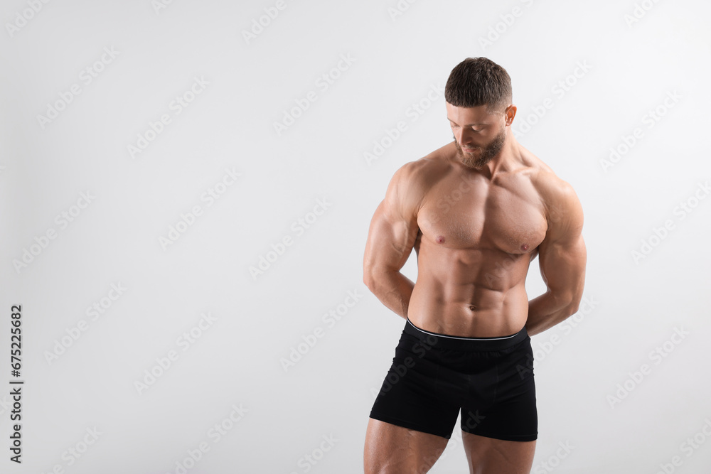 Young man is stylish black underwear on light grey background. Space for text Young man is stylish black underwear on light grey background. Space for text