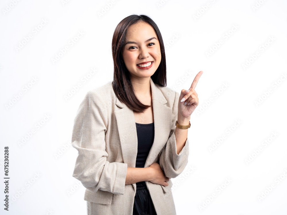A portrait of an Indonesian Asian woman wearing a cream-colored blazer, posing as if having an idea with her index finger pointing upward. Isolated against a white background. A portrait of an Indonesian Asian woman wearing a cream-colored blazer, posing as if having an idea with her index finger pointing upward. Isolated against a white background.