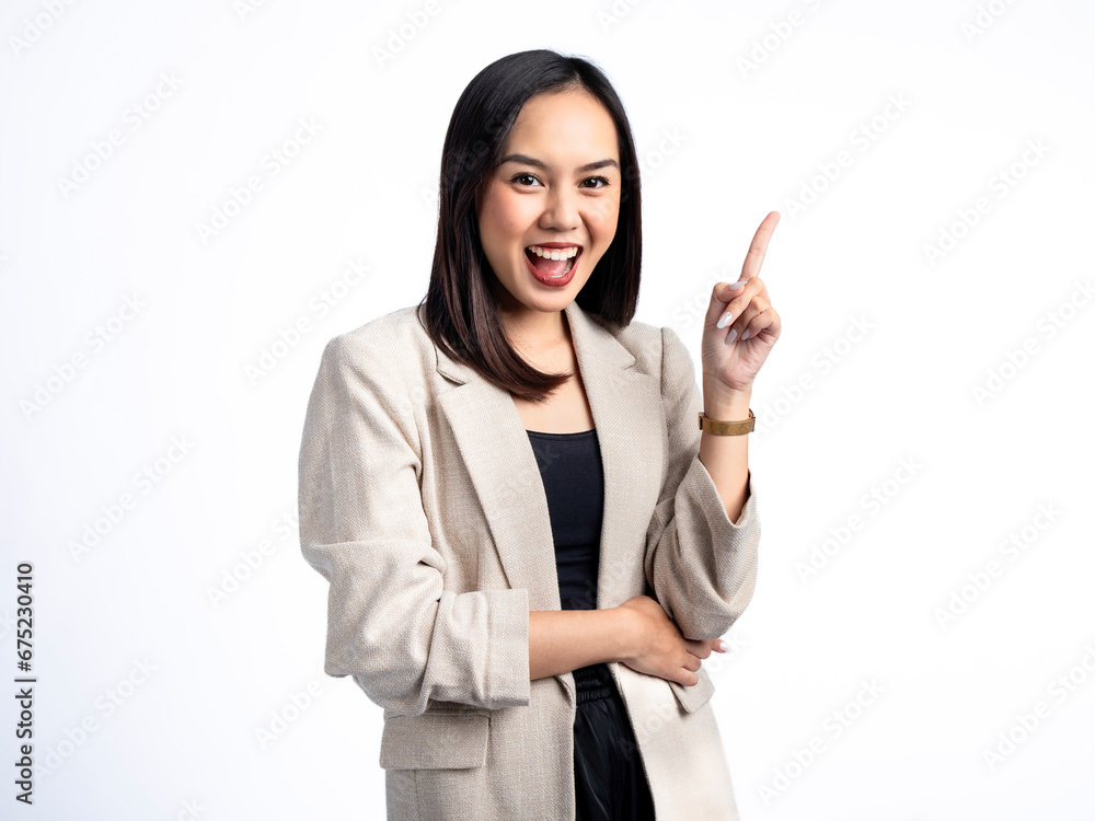 A portrait of an Indonesian Asian woman wearing a cream-colored blazer, posing as if having an idea with her index finger pointing upward. Isolated against a white background. A portrait of an Indonesian Asian woman wearing a cream-colored blazer, posing as if having an idea with her index finger pointing upward. Isolated against a white background.