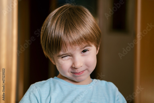 Portrait of smiling charming little toddler boy. He is giving a wink