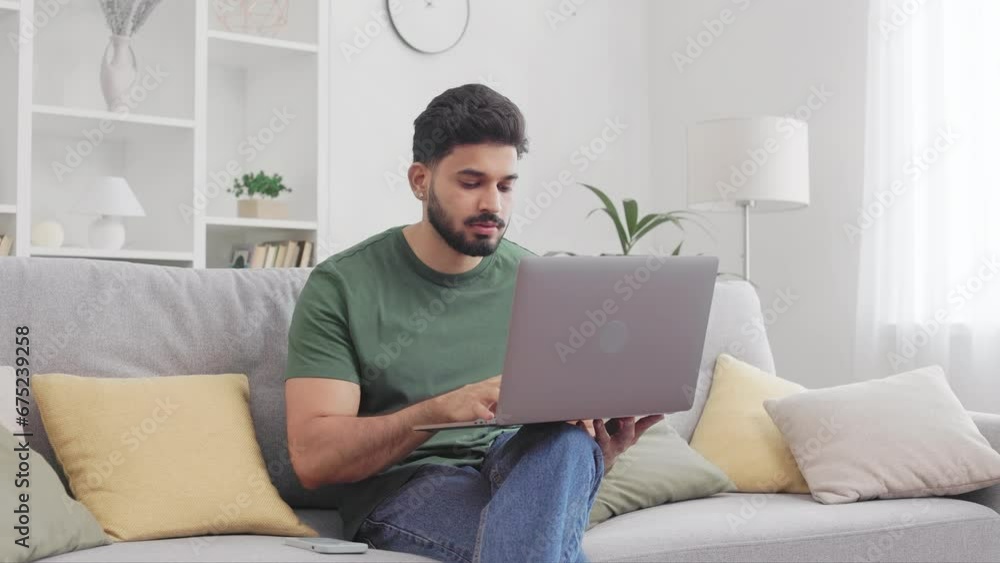 Casually dressed hindu man feeling sad of failure while working on modern laptop at home. Bearded young guy touching forehead and having stress during remote job experience. Casually dressed hindu man feeling sad of failure while working on modern laptop at home. Bearded young guy touching forehead and having stress during remote job experience.
