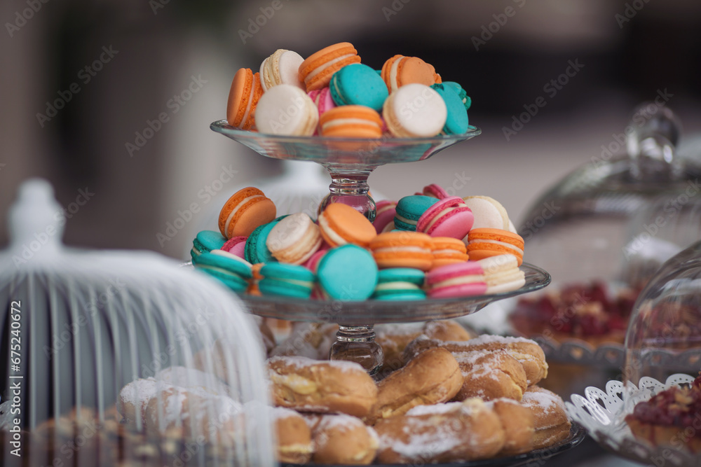 Tasty desserts, cakes and pastry on the wedding sweet buffet. macaroon on candy bar on holiday, candy bar at the wedding. Delicious wedding reception luxury ceremony. Table with sweets.