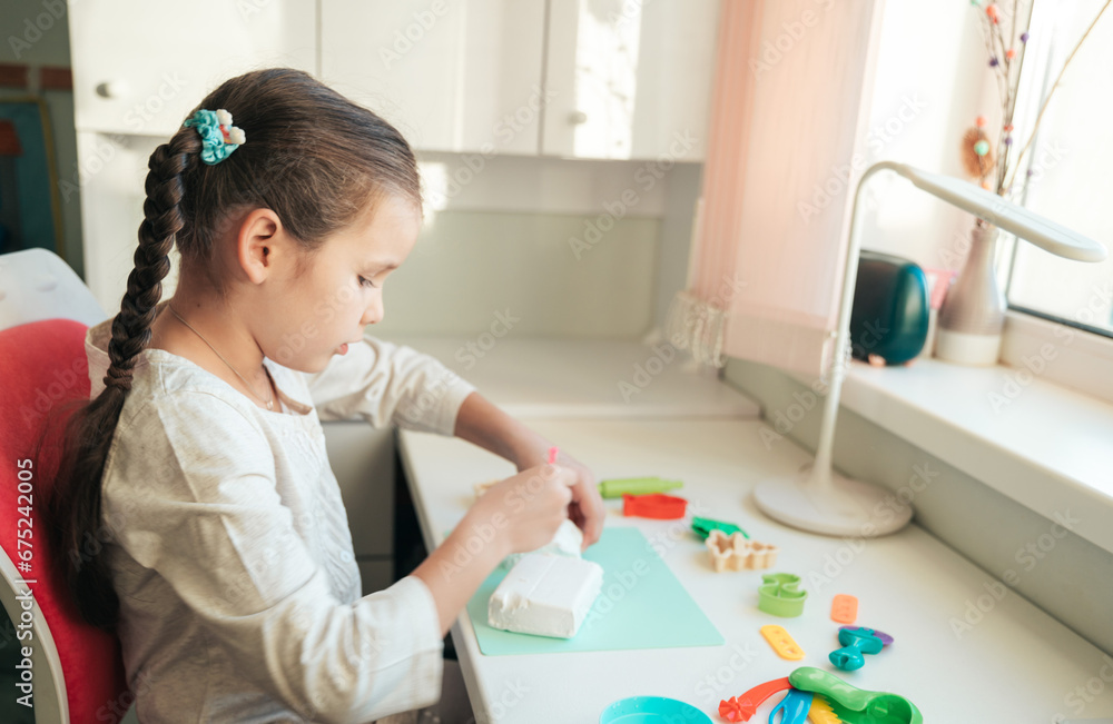 A beautiful girl sculpts from plasticine and clay. The child is creative. Development of fine motor skills. Modeling from plasticine. A beautiful girl sculpts from plasticine and clay. The child is creative. Development of fine motor skills. Modeling from plasticine.