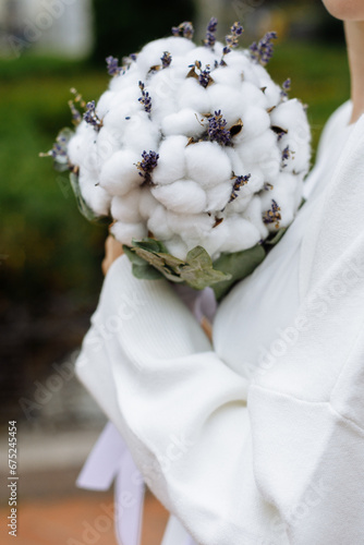 The bride is holding a wedding bouquet made of cotton