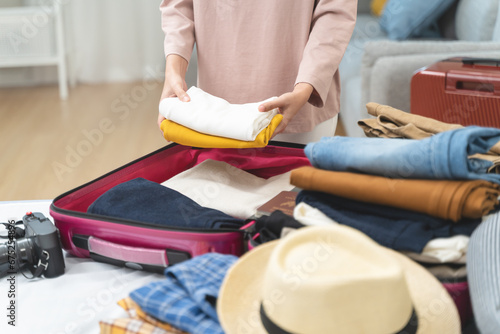 people packing outfit to suitcase for vacation trip