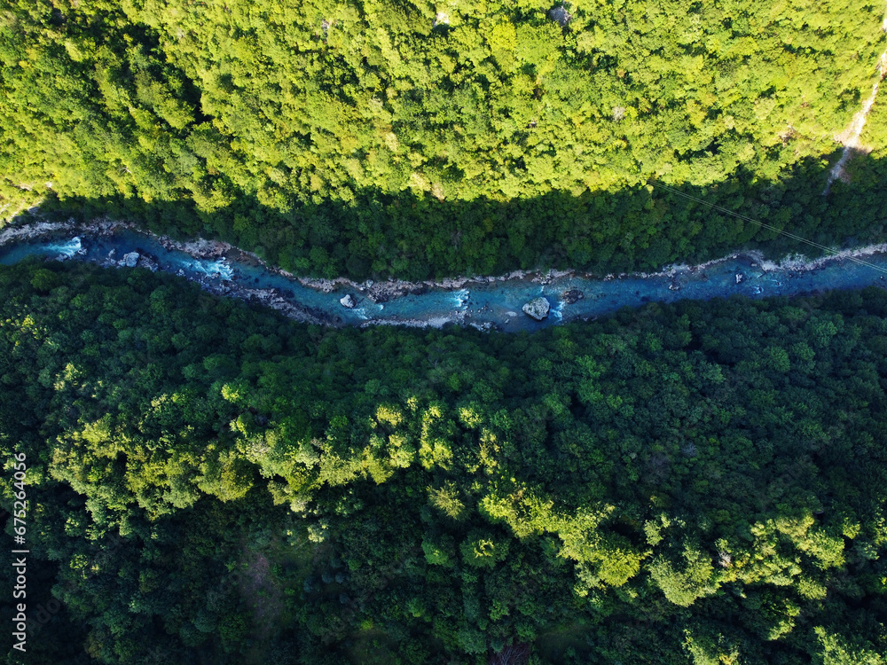 Aerial drone view: Flight over mountain river between green pine tree forest with light and shadow. Landscape panorama. Nature, travel, holidays. Carpathians, Ukraine, Europe. Camera go down. Aerial drone view: Flight over mountain river between green pine tree forest with light and shadow. Landscape panorama. Nature, travel, holidays. Carpathians, Ukraine, Europe. Camera go down.