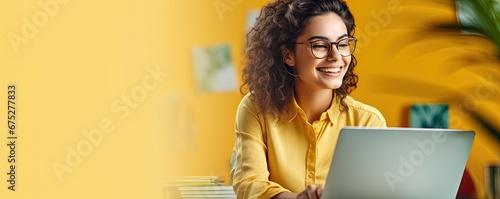 Happy young woman using laptop sitting at desk writing notes. Banner with empty copy space.