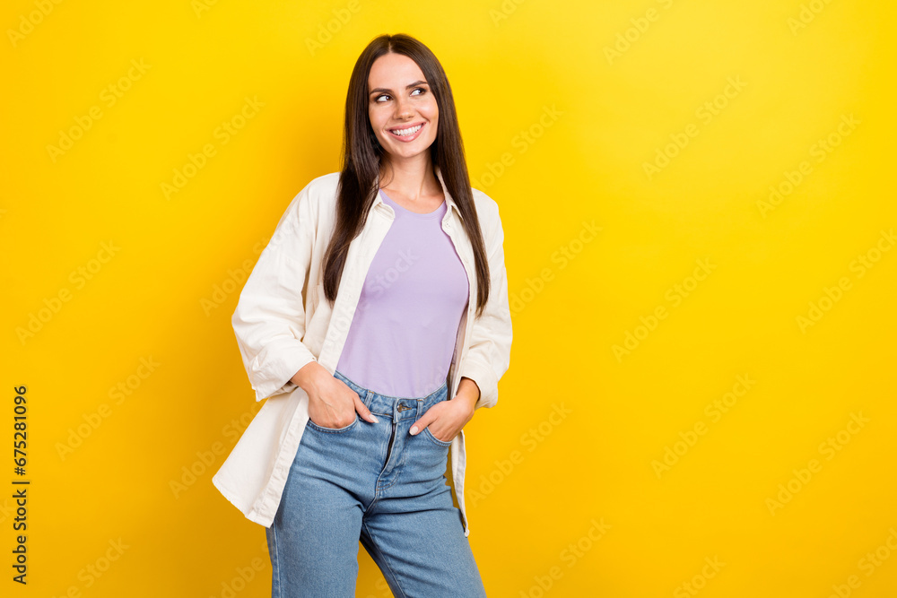 Photo portrait of attractive young woman look empty space arms pockets dressed stylish white clothes isolated on yellow color background Photo portrait of attractive young woman look empty space arms pockets dressed stylish white clothes isolated on yellow color background