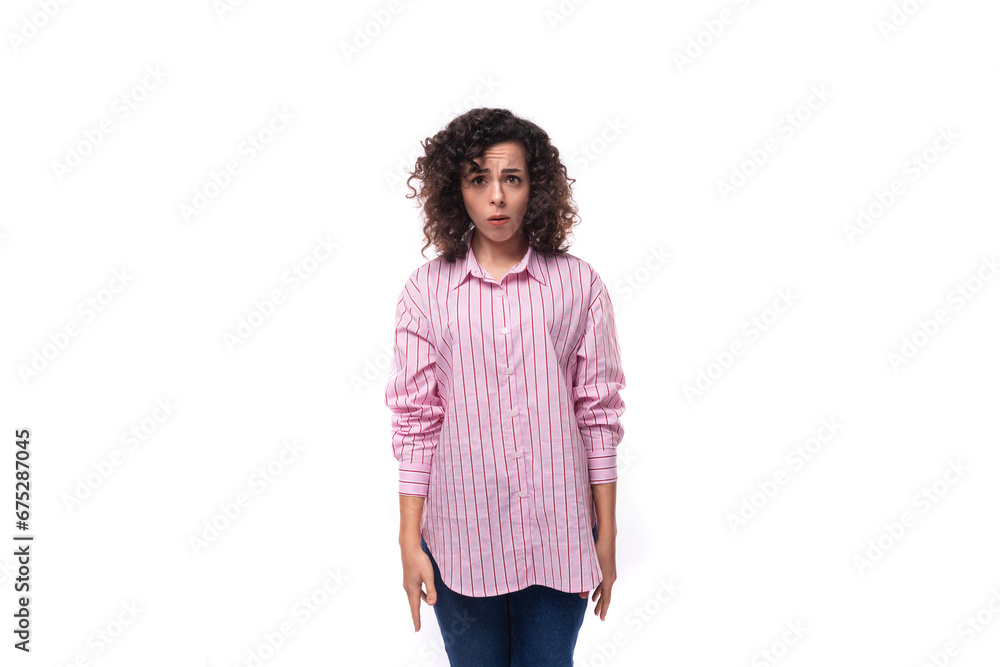 young tired european curly brunette ice in a pink blouse on the background with copy space young tired european curly brunette ice in a pink blouse on the background with copy space