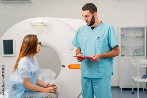 A radiologist consults a girl patient before undergoing diagnostics using an MRI machine in medical center