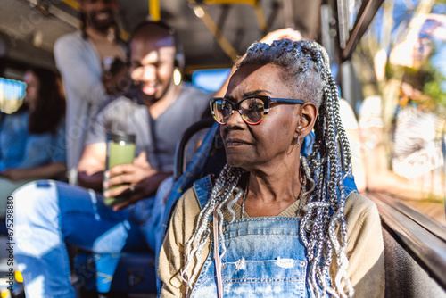 Mulher senior com pentedo afro, sentado no onibus lotado. photo