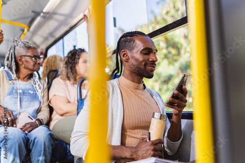 Young black man using smartphone during a bus ride.