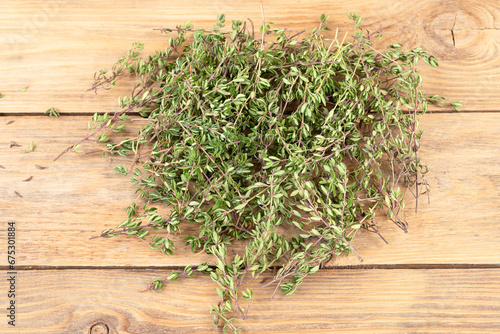 Close-up of fresh thyme sprigs on a wooden background.