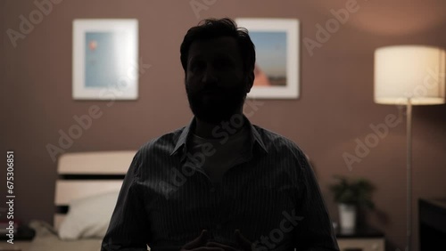 Hidden identity, hidden face, unknown person, silhouette interview. Dark silhouette of man talking to someone and looking at camera or at his interlocutor