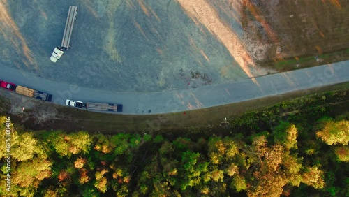 top down aerial hotshot type transportation, white pickup truck pulling gooseneck trailer flatbed. Macon, GA, USA