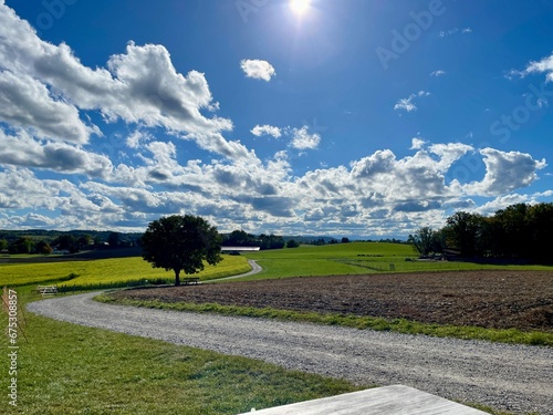 Kurviger Weg gen Horizont mit Blick in die weite bergige Ferne der bayerischen Alpen auf einem Herbstspaziergang bei Sonnenschein und Föhn und Blauem Himmel  photo