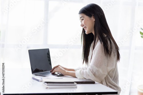 Portrait of Young Asian woman hand freelancer is working her job on computer tablet in modern office. Doing accounting analysis report real estate investment data, Financial and tax systems concept.