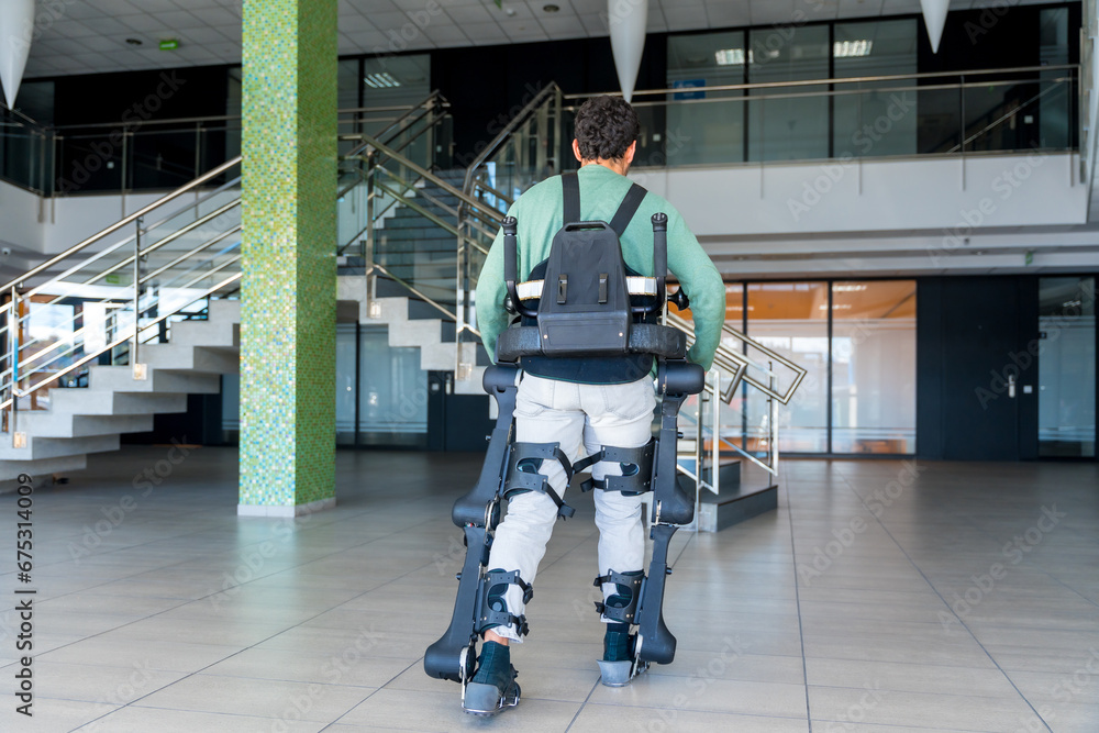 Mechanical exoskeleton, disabled person on his back walking with the help of robotic skeleton, physiotherapy in a modern hospital, futuristic physiotherapy Mechanical exoskeleton, disabled person on his back walking with the help of robotic skeleton, physiotherapy in a modern hospital, futuristic physiotherapy